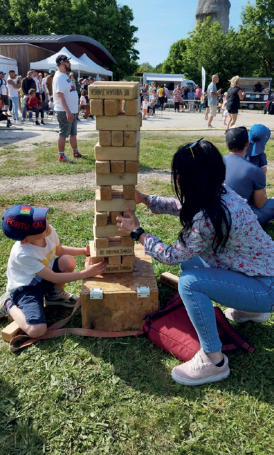 Femme et enfant jouant à qui fera s’effondrer une grande tour en bois