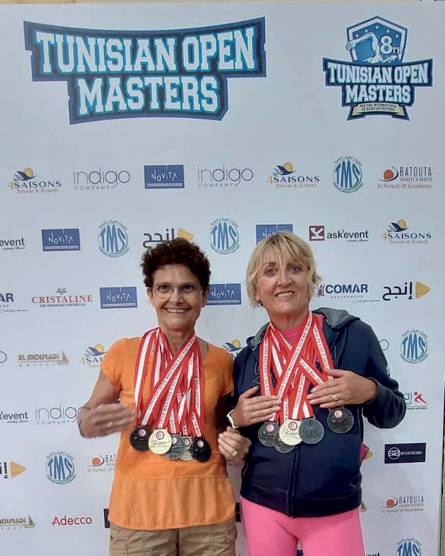 Les deux nagueuses arborent leurs médailles devant un panneau de sponsors du Tunisian Open Masters